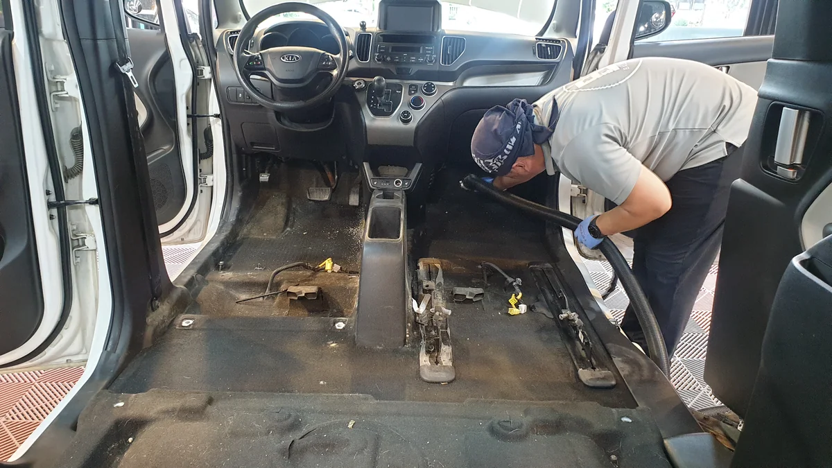 좌석을 탈거한 바닥에서 작업자와 장비가 함께 보이는 장면